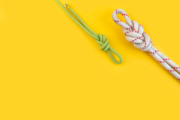 Rope with the Knot eight. Isolated on the yellow background. Minimal concept, copy space.

