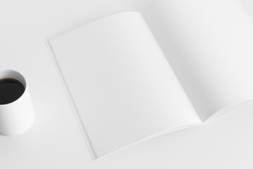 Open magazine mockup with a cup of coffee  on the white table.