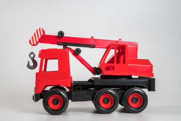 Fototapeta premium Multi-colored plastic children's toy cars on a white background. Red truck crane.