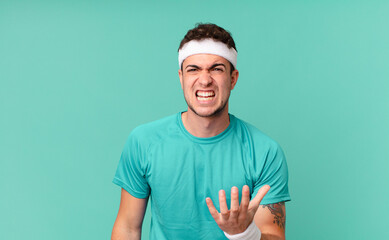 fitness man looking angry, annoyed and frustrated screaming wtf or what’s wrong with you