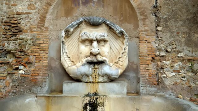 The old fountain, decorated by a marble mask, survived from the time of the Roman Empire and located on the Aventine Hill