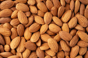 Almond background. Almonds top view background. Whole almond nuts flat lay. Full depth of field.