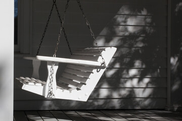 Wooden porch swing in the sunshine