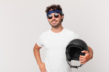 motorbike rider smiling happily with a hand on hip and confident, positive, proud and friendly...