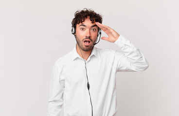 telemarketer looking happy, astonished and surprised, smiling and realizing amazing and incredible...