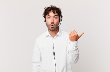 telemarketer looking astonished in disbelief, pointing at object on the side and saying wow,...