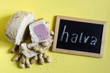Peanut and sesame halva with decoration in the form of peanuts and sesame seeds on a yellow...