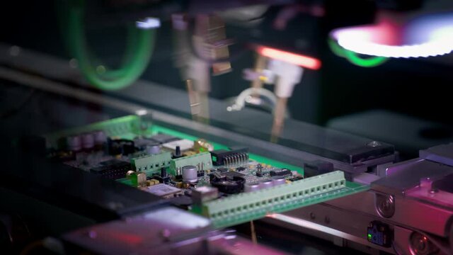Production of electronic circuit boards. Machine for automatic installation of components on an electronic board. Manufacturing of microcircuits and microprocessors. The transistors are installed.
