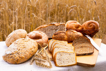 lot of different flavored bread, wheat, rye, on the table in the field outside