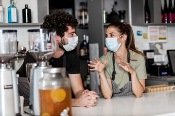 Team work spirit.Millennial business team wear protective masks, posing in coffee shop during corona virus.