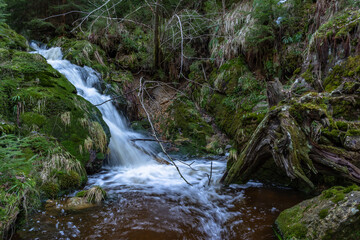 Cascade falls over mossy rocks