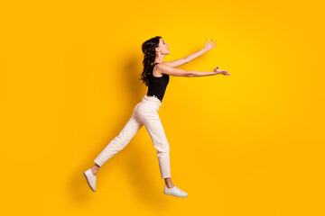 Fototapeta na wymiar Full length body size side profile photo of woman jumping up opened hands missing someone isolated vivid yellow color background