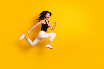 Fototapeta na wymiar Full length body size side profile photo of woman jumping running cheerfully on sale isolated vivid yellow color background