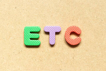 Foam alphabet letter in word etc (abbreviation of et cetera) on wood background