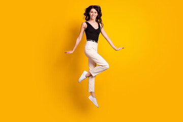 Fototapeta na wymiar Full length body size photo of funny woman jumping up gracefully wearing stylish outfit isolated on vivid yellow color background