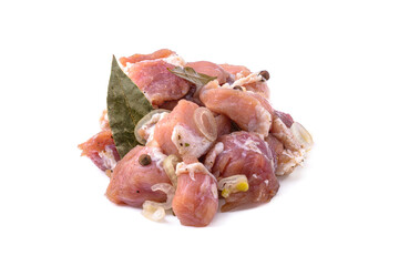 Raw pieces of pork shish kebab in marinade with pepper, onion,bay leaf, ready to cook, barbecue meat, isolated on a white background.