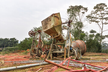 The rusty, decrepit concrete mixer was abandoned outdoors