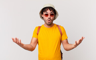 hispanic tourist man open-mouthed and amazed, shocked and astonished with an unbelievable surprise