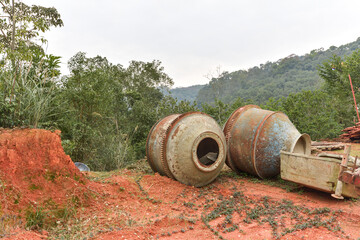 The rusty, decrepit concrete mixer was abandoned outdoors