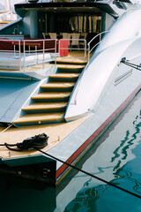 Side view of a stern trawl of beautiful motor white yacht moored to the pier