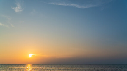 Obraz premium sunset sky over the sea in the evening with colorful orange sunlight 