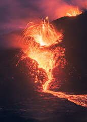 Lava exploding in from the volcano, with bright lights and lava bits erupting from the crater in Iceland. 