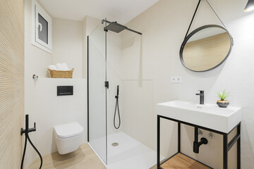 Modern style bathroom in bright colors in refurbished apartment. Shower zone, sink with black...