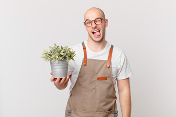 gardener man with cheerful, carefree, rebellious attitude, joking and sticking tongue out, having...