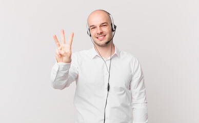 telemarketer smiling and looking friendly, showing number three or third with hand forward,...