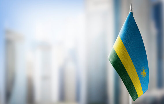 A small flag of Rwanda on the background of a blurred background