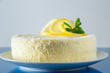 Lemon cake with coconut flakes and white cream, vanilla holiday dessert.