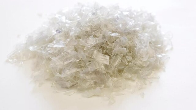 A Pile of PET bottle flakes. Crushed plastic bottle. PET. Plastic bottle recycling, recyclable materials, production and factories. Save environment concept. Recycle icon,picking up, PET icon.