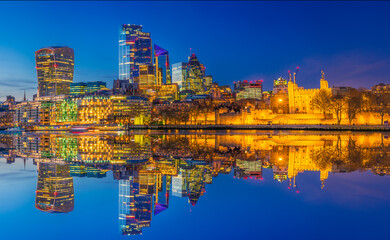 Fototapeta premium Tower of London and financial district of London reflected at dusk