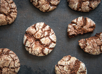 Chocolate Crinkle cookies on a black background. Cracked chocolate biscuits