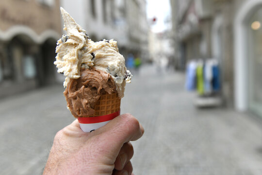 Ein Mann h&auml;lt eine Eist&uuml;te in der Hand - A man is holding an ice cream cone