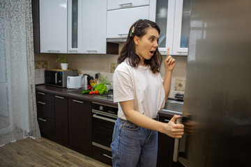 woman opened fridge thinking what to cook