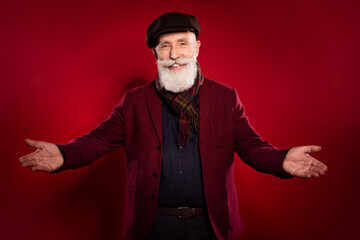 Photo portrait of elder man wearing scarf blazer headwear inviting on meeting isolated vivid red...