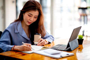 Business young female working analyzing investment charts on calculator and tablet,Work From Home concept.