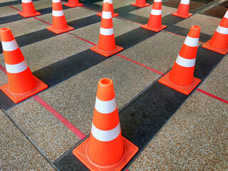 Traffic plastic cones are used instead of standing in order to society distance.