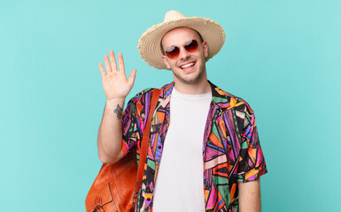 tourist man smiling happily and cheerfully, waving hand, welcoming and greeting you, or saying...
