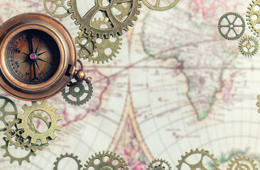 Fototapeta na wymiar Compass with gears and cogs and an old map.