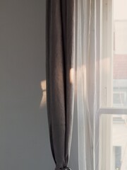 morning sunlight on the grey stylish window curtains inside of our flat