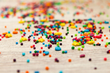 Sugar sprinkled on a white wooden background. Bright colors and sweet taste. Sprinkle for Easter icing. Preparing for Easter