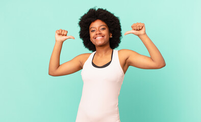 black afro woman feeling proud, arrogant and confident, looking satisfied and successful, pointing...