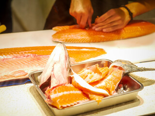 The chef cuts the salmon on the table.Salmon meat for special dish.