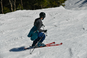 Freerider seen from behind making a turn in Stowe Mountain resort in Vermont during Spring in mid-April warm sunny day.