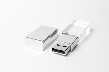 Glass USB stick with a metal cap on grey background. Close-up photo. Copy space. A high resolution.