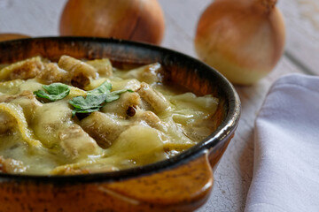 Close-up of a traditional onion soup, topped with croutons and cheese.