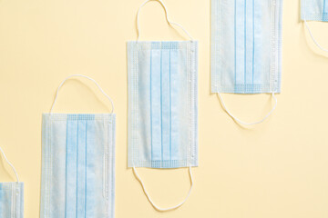 The overhead view of the disposable protective masks lying on a beige background