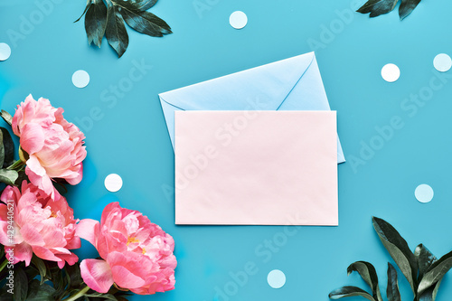 Mother's day greeting card design with pink peony flowers on blue mint paper background. with paper confetti, text space. Trendy casual arrangement, top view. Summer birthday or anniversary card.